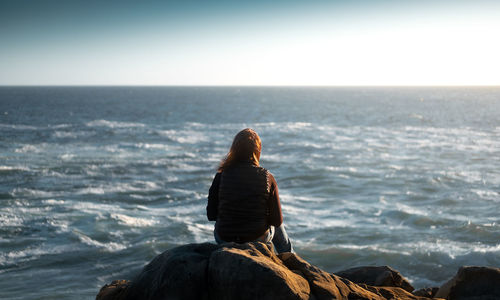 Rear view of woman looking at sea against sky