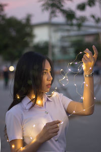 woman holding illuminated string lights