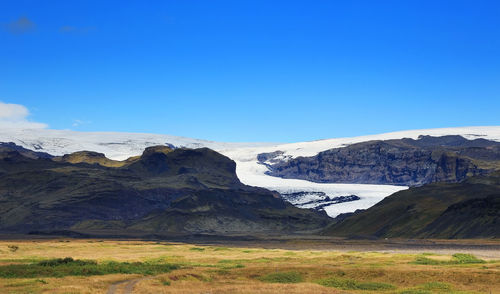 Scenic view of mountains against clear blue sky