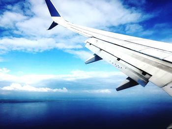 Airplane flying over sea against sky