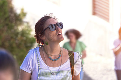 Portrait of young woman wearing sunglasses while standing outdoors