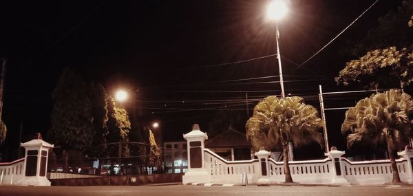 Low angle view of illuminated street lights at night