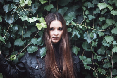 Portrait of young woman with plants