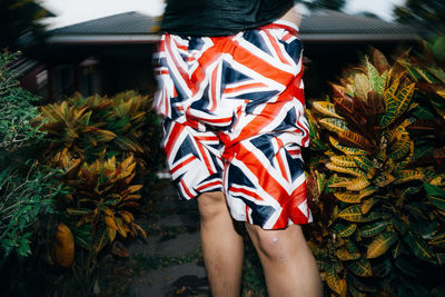 Low section of woman standing against plants