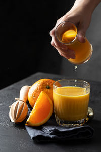 Close-up of hand holding orange juice