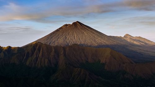 View of volcanic mountain range against cloudy sky