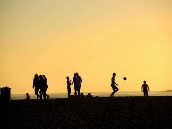 Silhouette people at beach during sunset