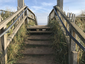 Low angle view of staircase on field against sky