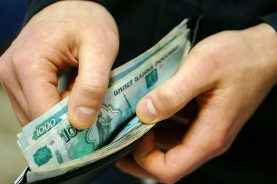 Cropped image of person counting money in wallet