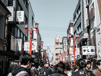 People on street in city against sky