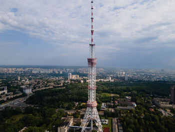 Aerial view of buildings in city against cloudy sky