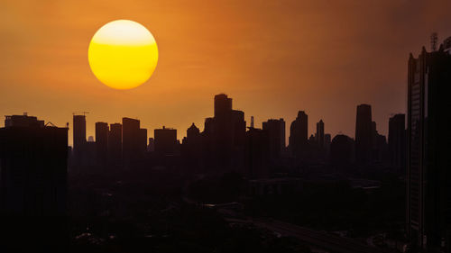 Silhouette buildings against sky during sunset