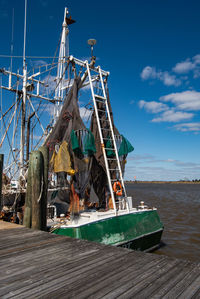 Sailboats moored in sea against blue sky