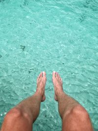 Low section of person legs in swimming pool