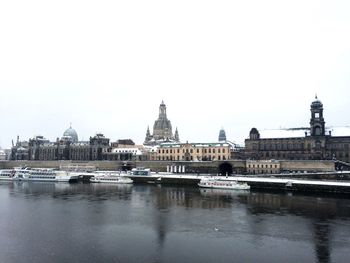 Boats in river with buildings in background