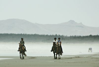 Men standing on landscape against mountains