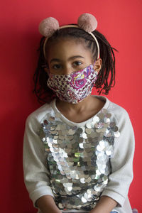 Portrait of girl standing against red wall