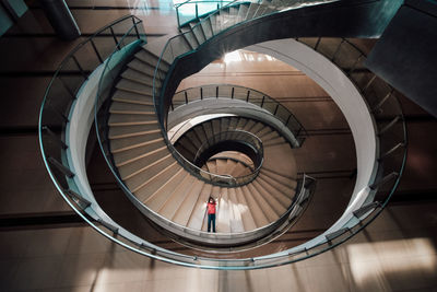 Boy lying on steps of spiral staircase