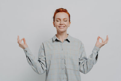 Portrait of young businesswoman standing against white background