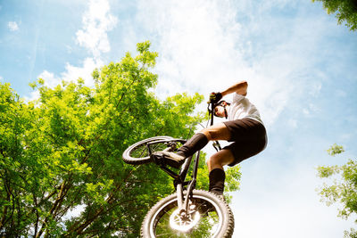 Low angle view of man riding bicycle against sky