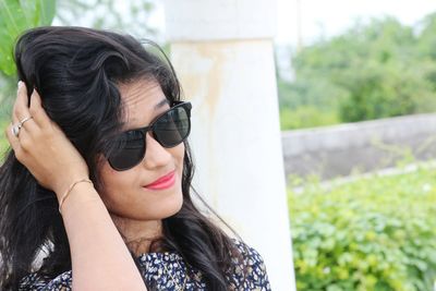 Close-up portrait of young woman wearing sunglasses