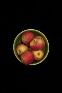 Close-up of apples in bowl against black background