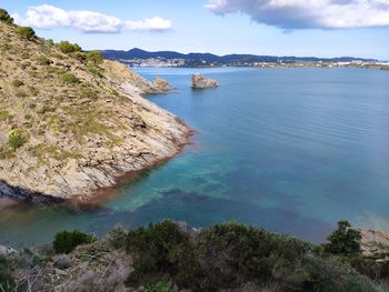 High angle view of rocks by sea against sky