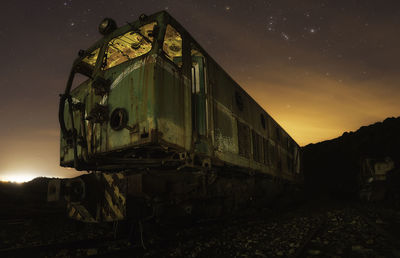 Abandoned train against sky at night