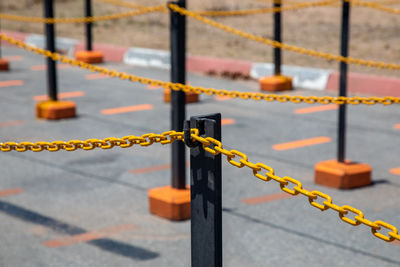 Close-up of metal fence against orange wall