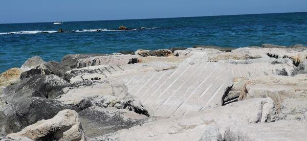 Scenic view of rocks on beach against sky