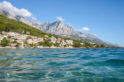 Scenic view of sea and mountains against blue sky