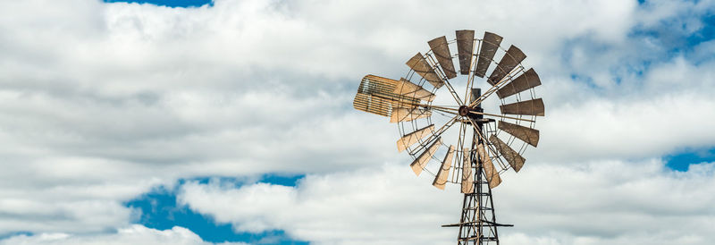 Low angle view of windmill against sky