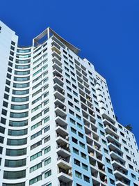 Low angle view of modern building against blue sky