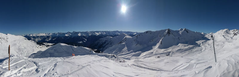 Scenic view of snowcapped mountains against clear blue sky