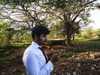 Side view of young man standing on field