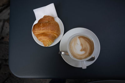 True italian breakfast, cappuccino coffee and a brioche on the street