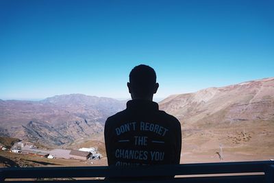 Man on mountain against clear sky