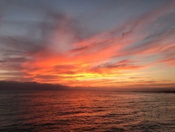 Scenic view of sea against dramatic sky during sunset