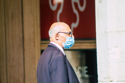 Portrait of man standing against wall