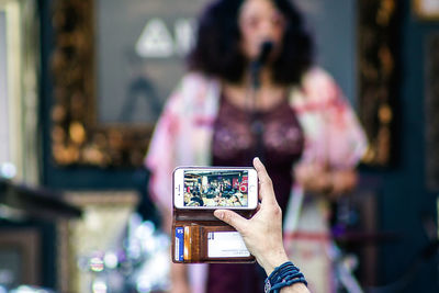 Close-up of woman photographing mobile phone