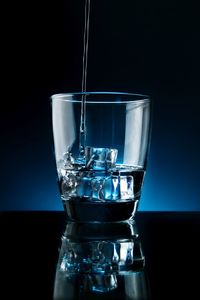 Close-up of wine glass against blue background