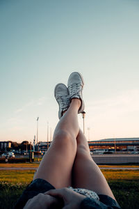 Low section of woman resting against sky