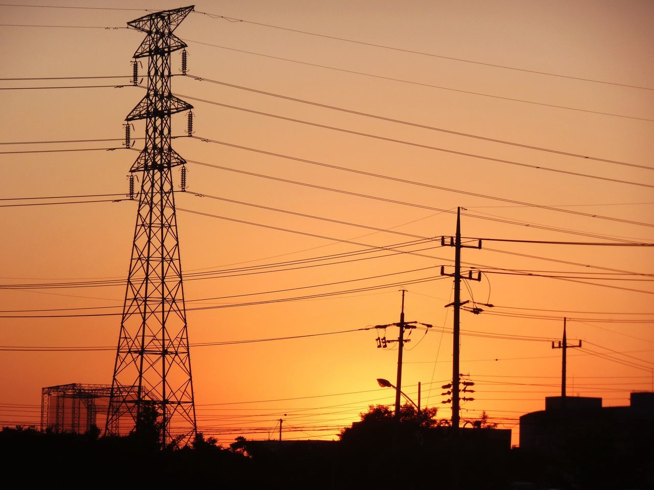 SILHOUETTE OF ELECTRICITY PYLON AT SUNSET