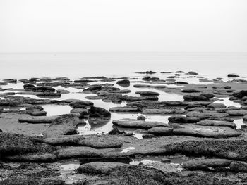 Rocks on beach against clear sky