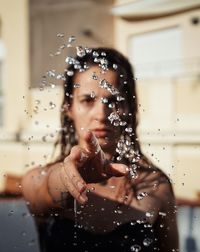 Portrait of woman playing with water drops in summer 