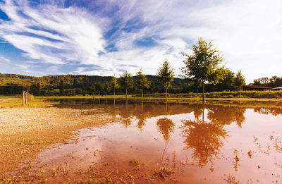 Scenic view of lake against cloudy sky
