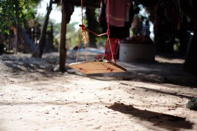Close-up of empty swing hanging on sand