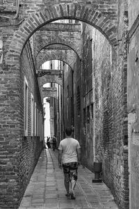 Rear view of man walking on road