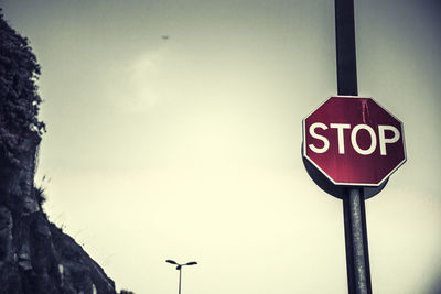 Low angle view of road sign against clear sky