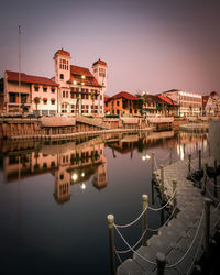 Pier over lake in city against sky